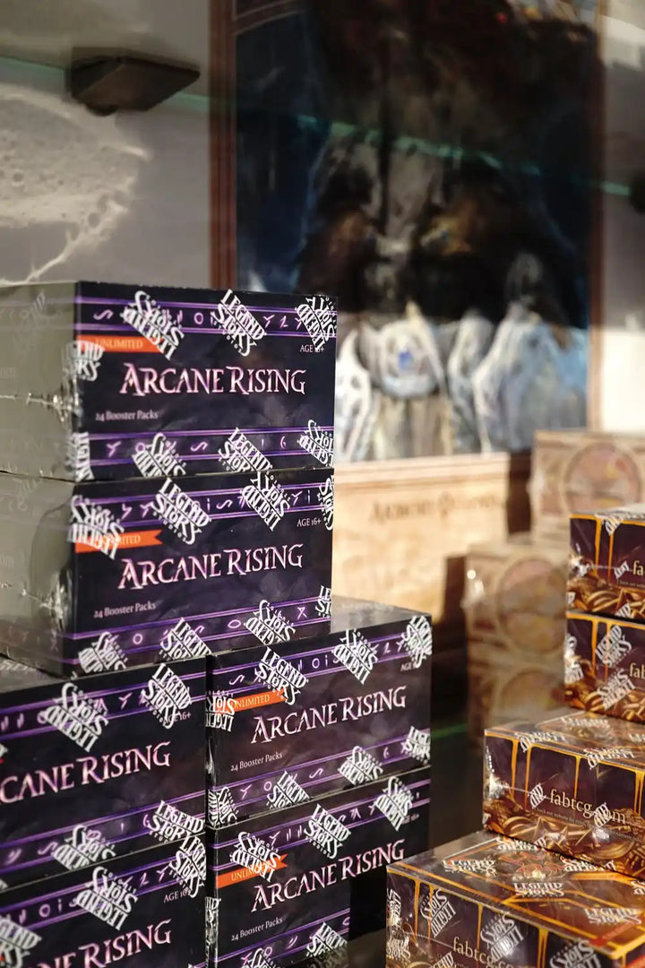 Stapel von lila ‘Arcane Rising’ Kartenspielboxen mit weißen dekorativen Mustern.